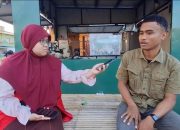 Putri Aisyah Kurnia Mahasiswi KKN Unhas Melaksanakan Pemasangan Visual Poster Edukasi Pemilahan Sampah di Kelurahan Bira.