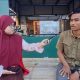 Putri Aisyah Kurnia Mahasiswi KKN Unhas Melaksanakan Pemasangan Visual Poster Edukasi Pemilahan Sampah di Kelurahan Bira.